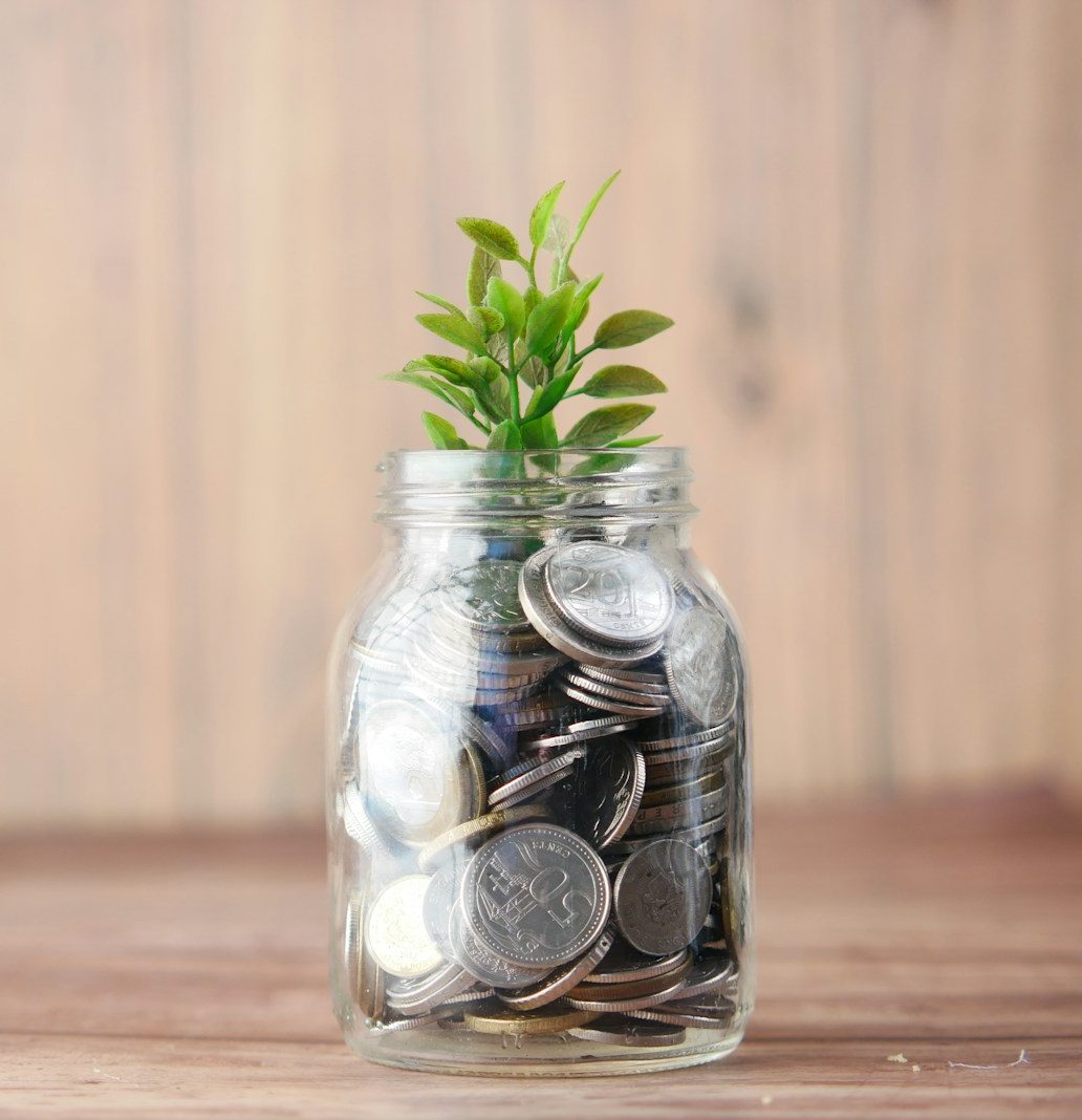 a glass jar filled with coins and a plant